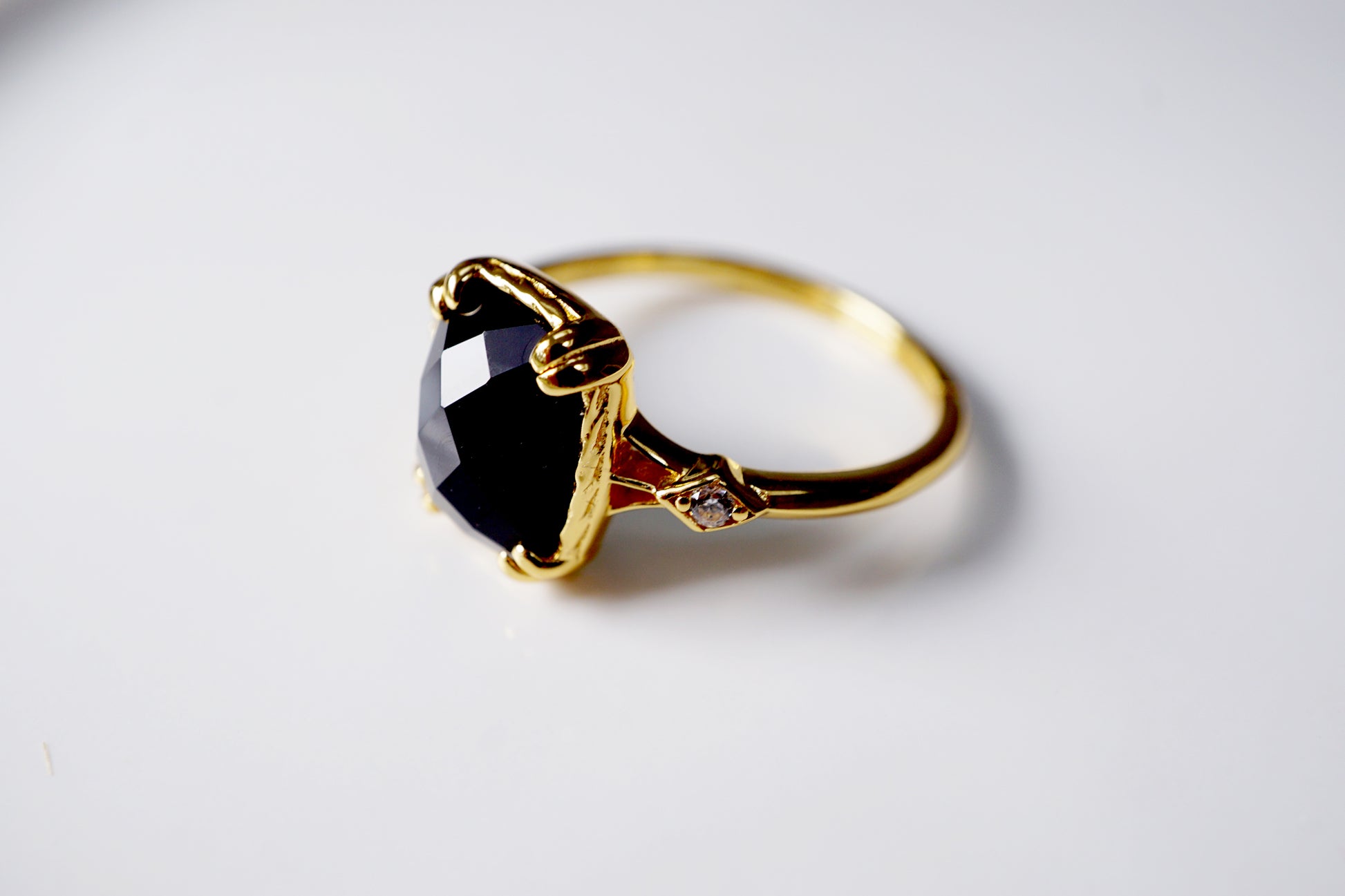 Gold ring with a black gemstone on a white background