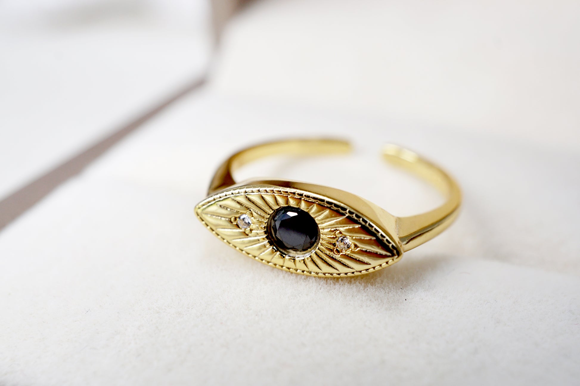 Gold ring with black gemstone on a white background