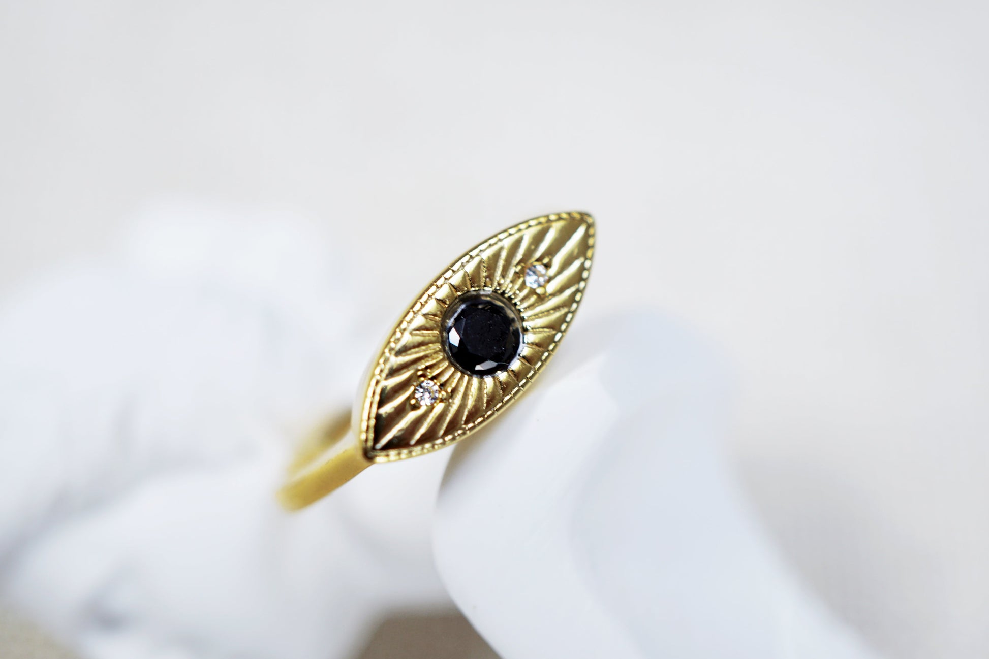 Gold ring with a black gemstone on a white background