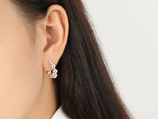 Close-up of an ear wearing a pearl earring with a blurred background