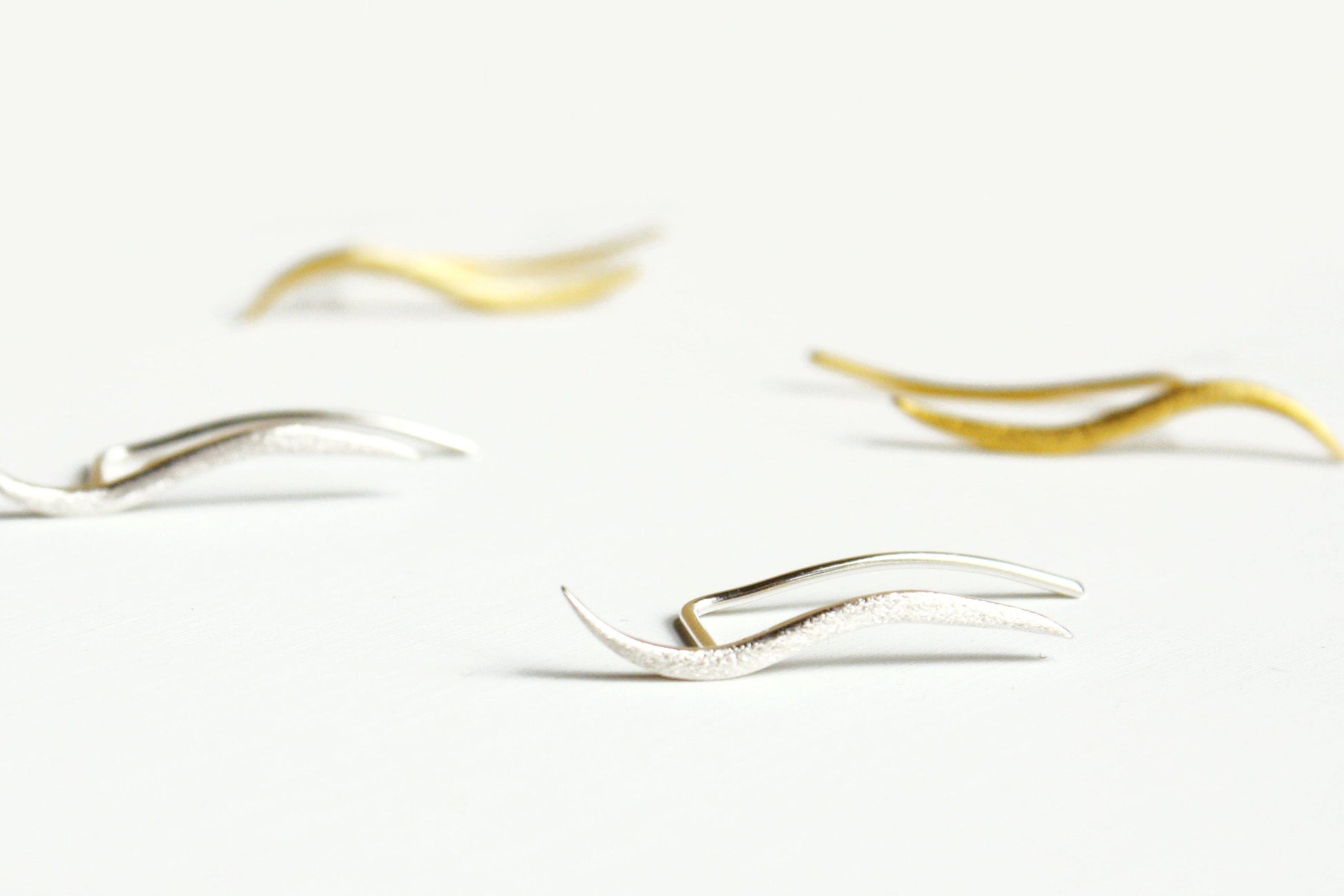 Gold and silver earrings on a white background