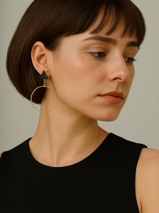 Woman wearing gold hoop earrings with a neutral background