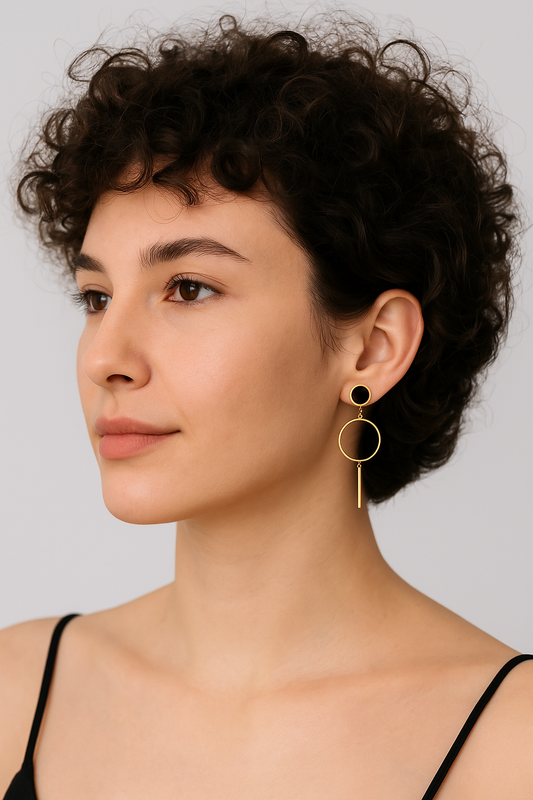 Woman wearing gold hoop earrings against a neutral background