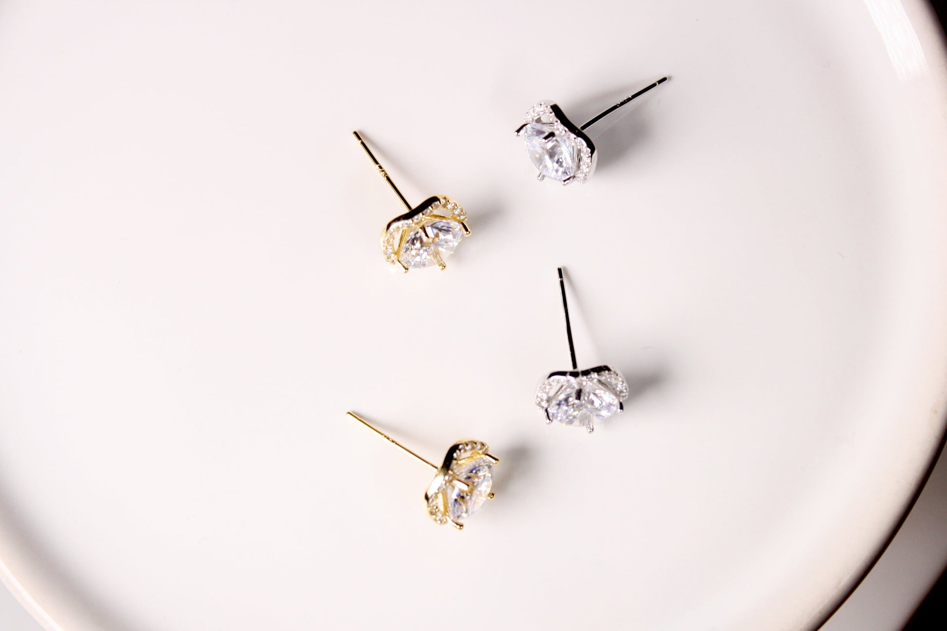 Set of diamond stud earrings on a white plate