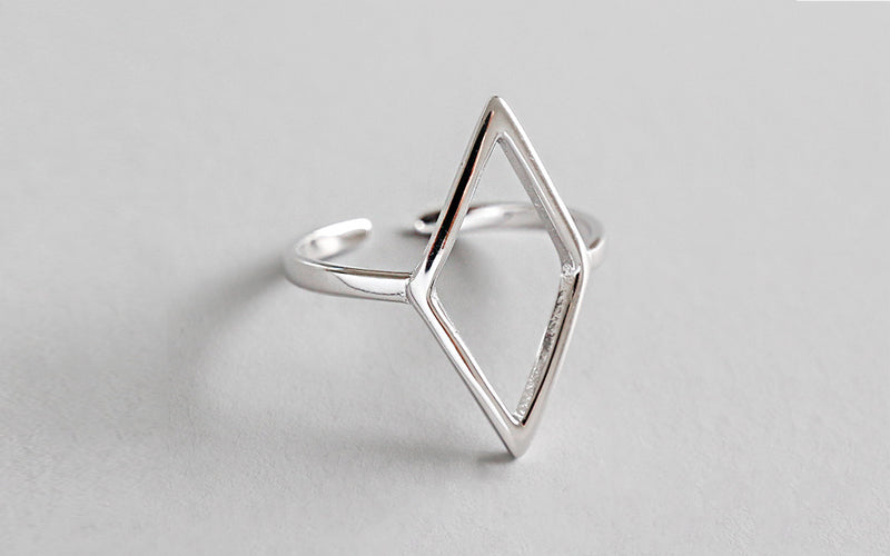 Silver geometric ring on a light gray background