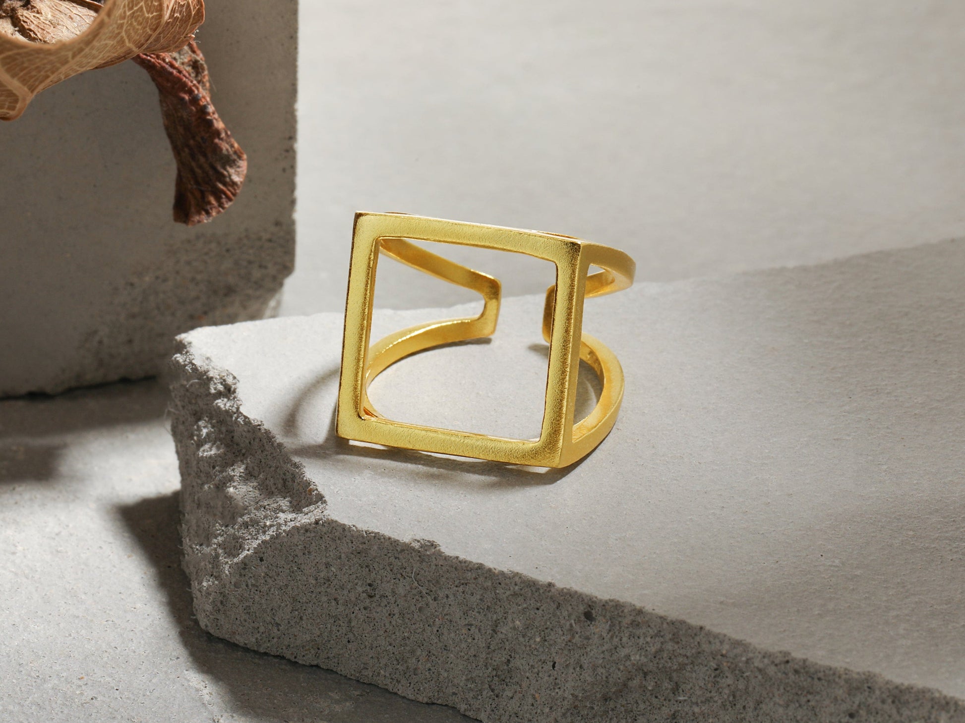 Gold ring on a textured surface with a neutral background