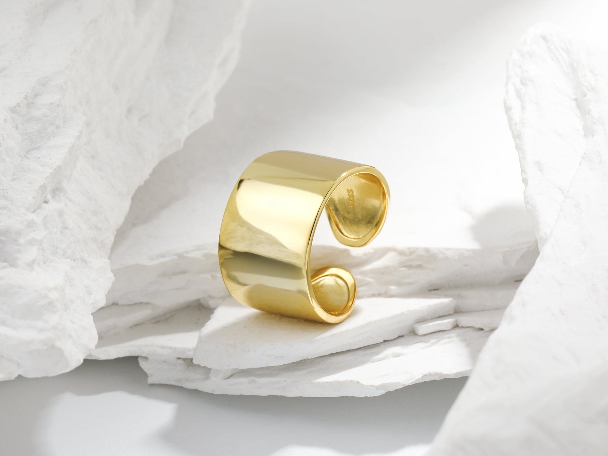 Gold ring on a textured white surface