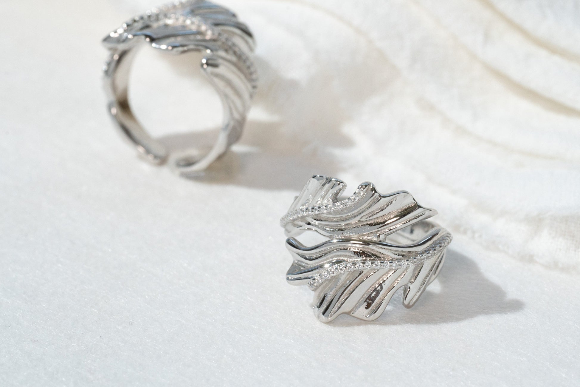 Silver hoop earrings on a white fabric background