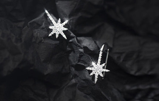 Star-shaped earrings on a textured black surface