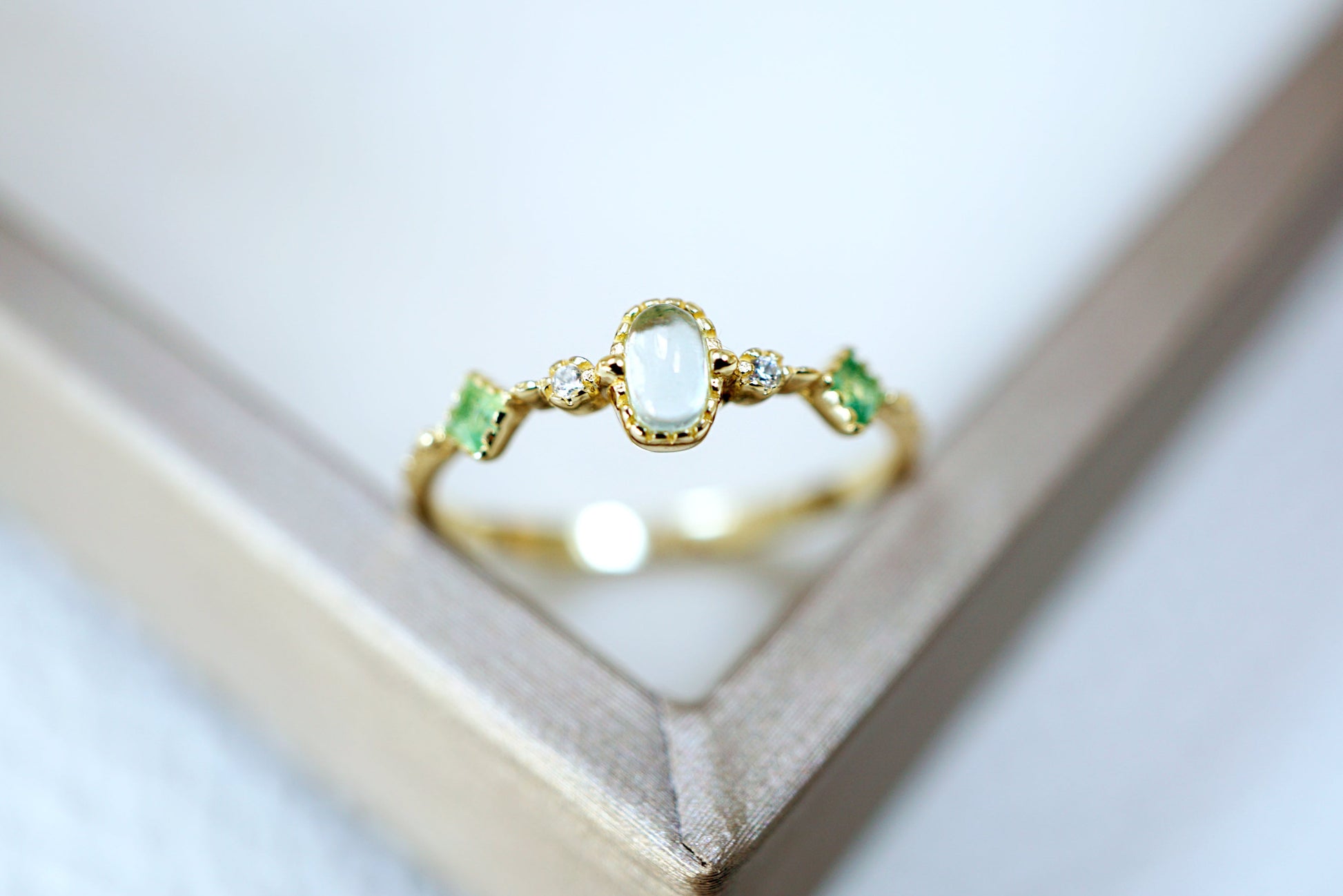 Gold ring with a central gemstone and smaller stones on a white background