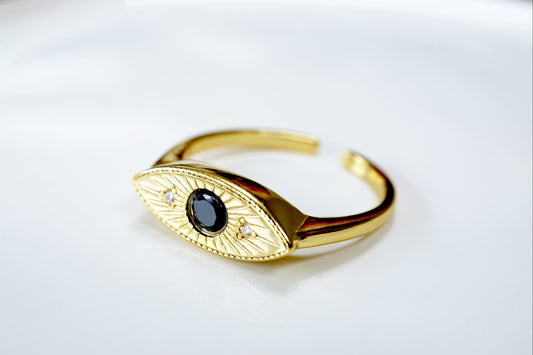 Gold bracelet with a black gemstone on a white background