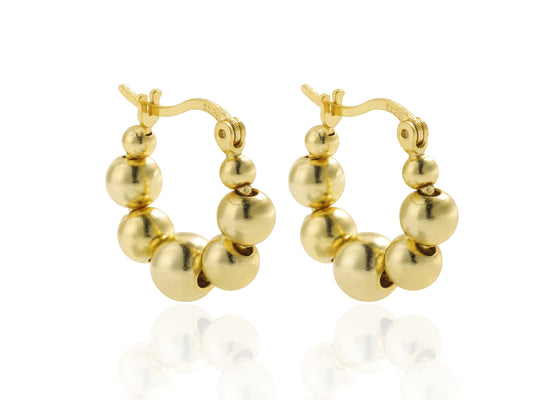 Gold hoop earrings with spherical beads on a white background