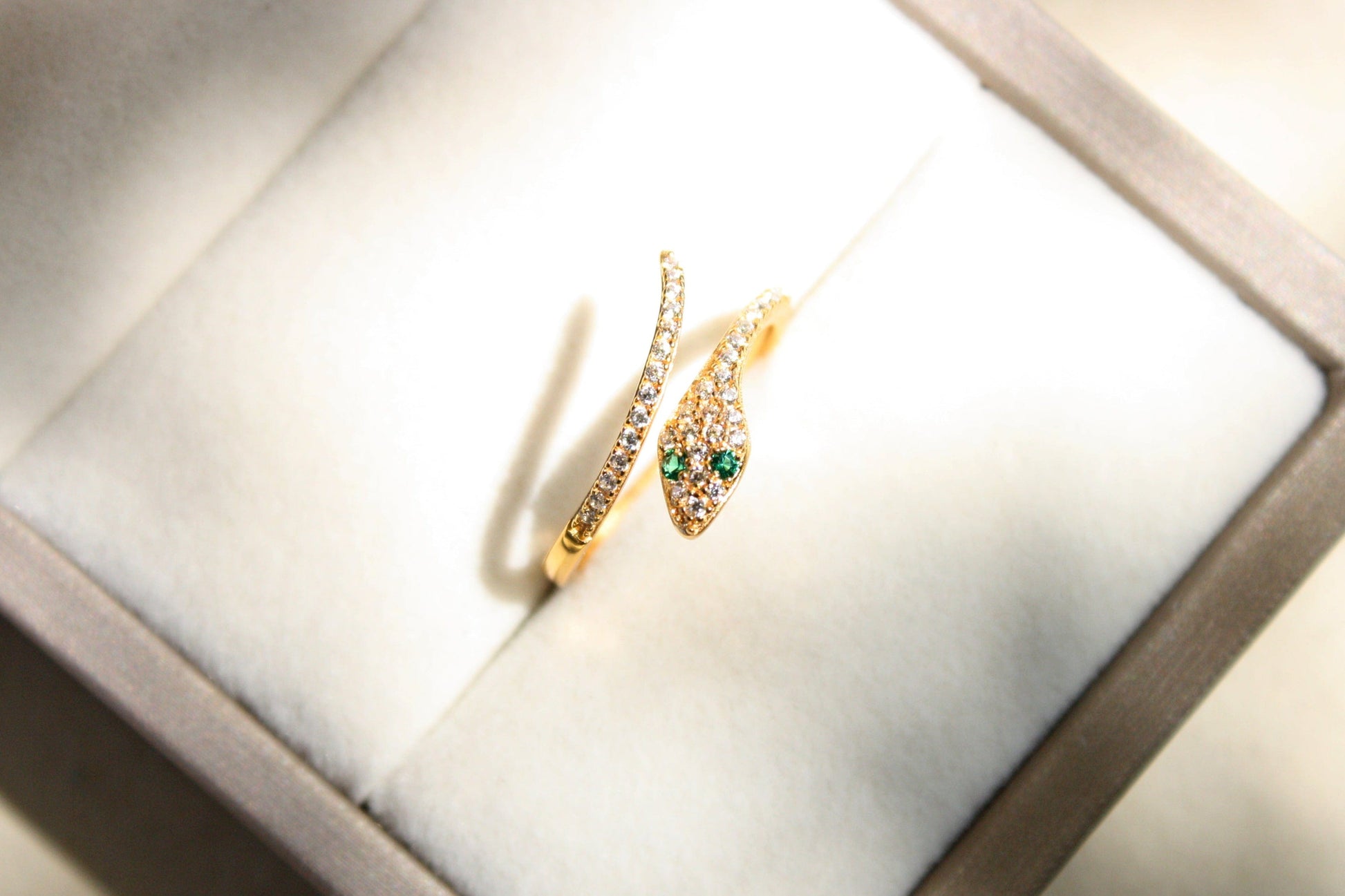 Gold bracelet with green gemstones in a jewelry box