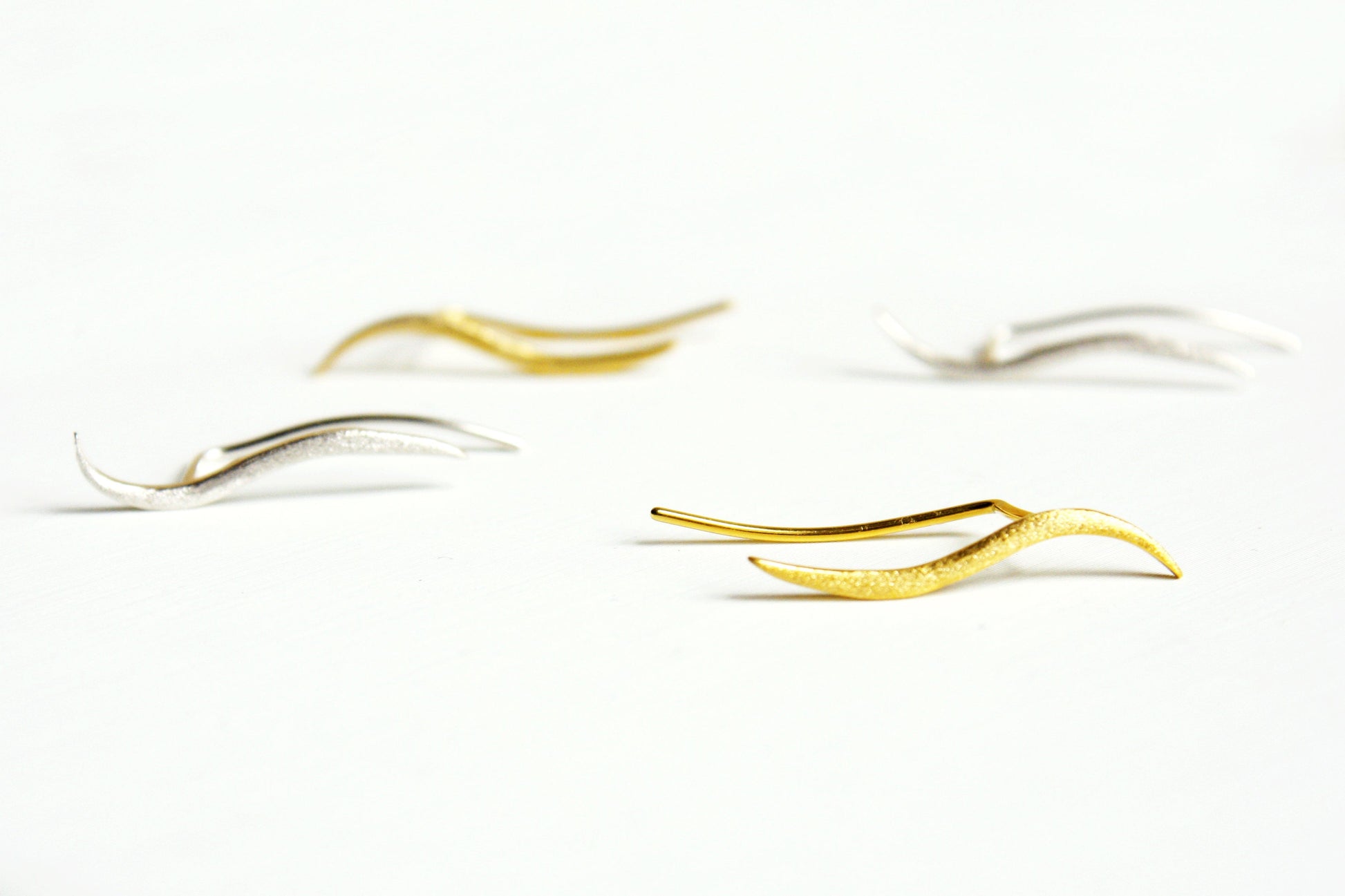 Gold and silver earrings on a white background