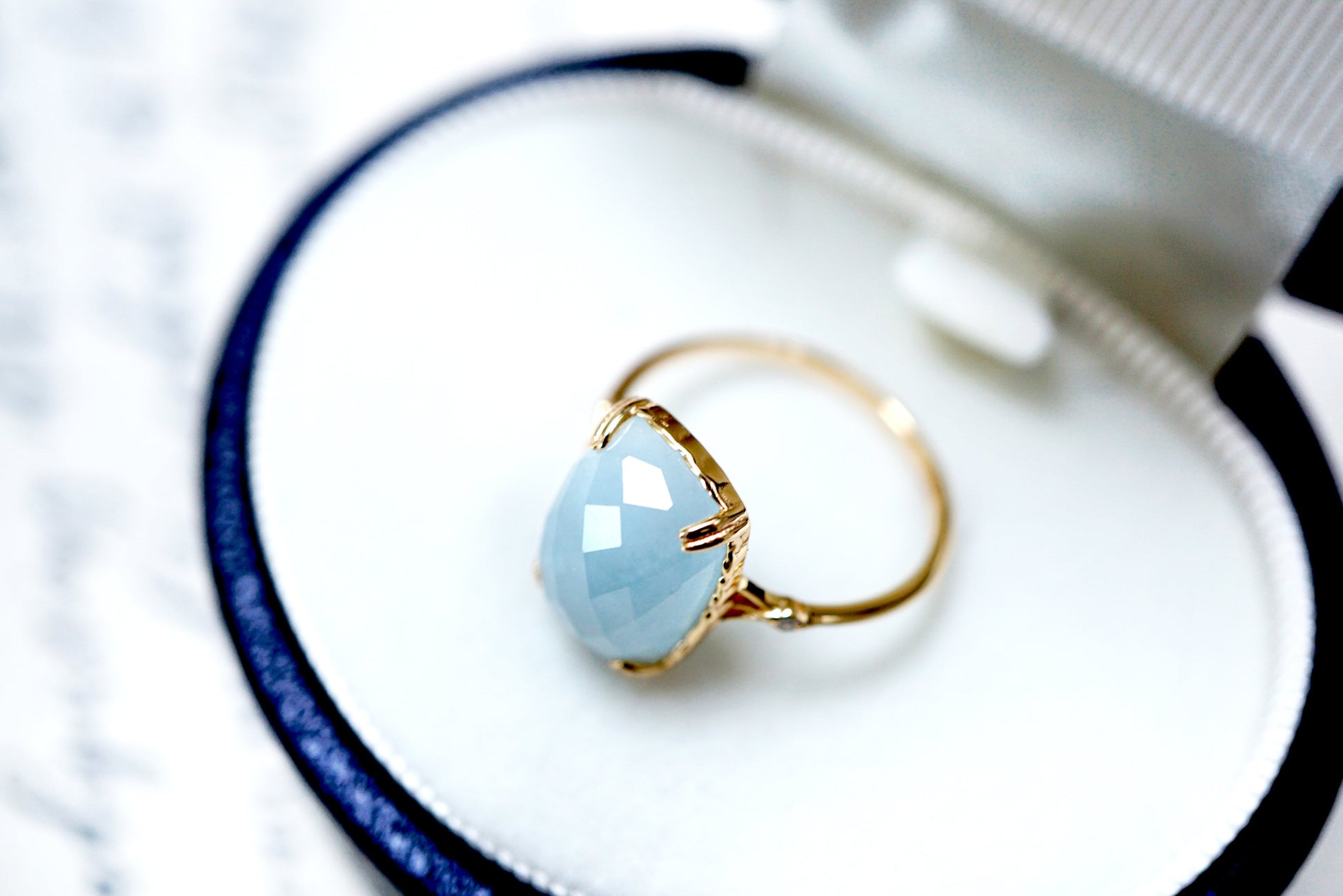 Gold ring with a blue gemstone in a jewelry box