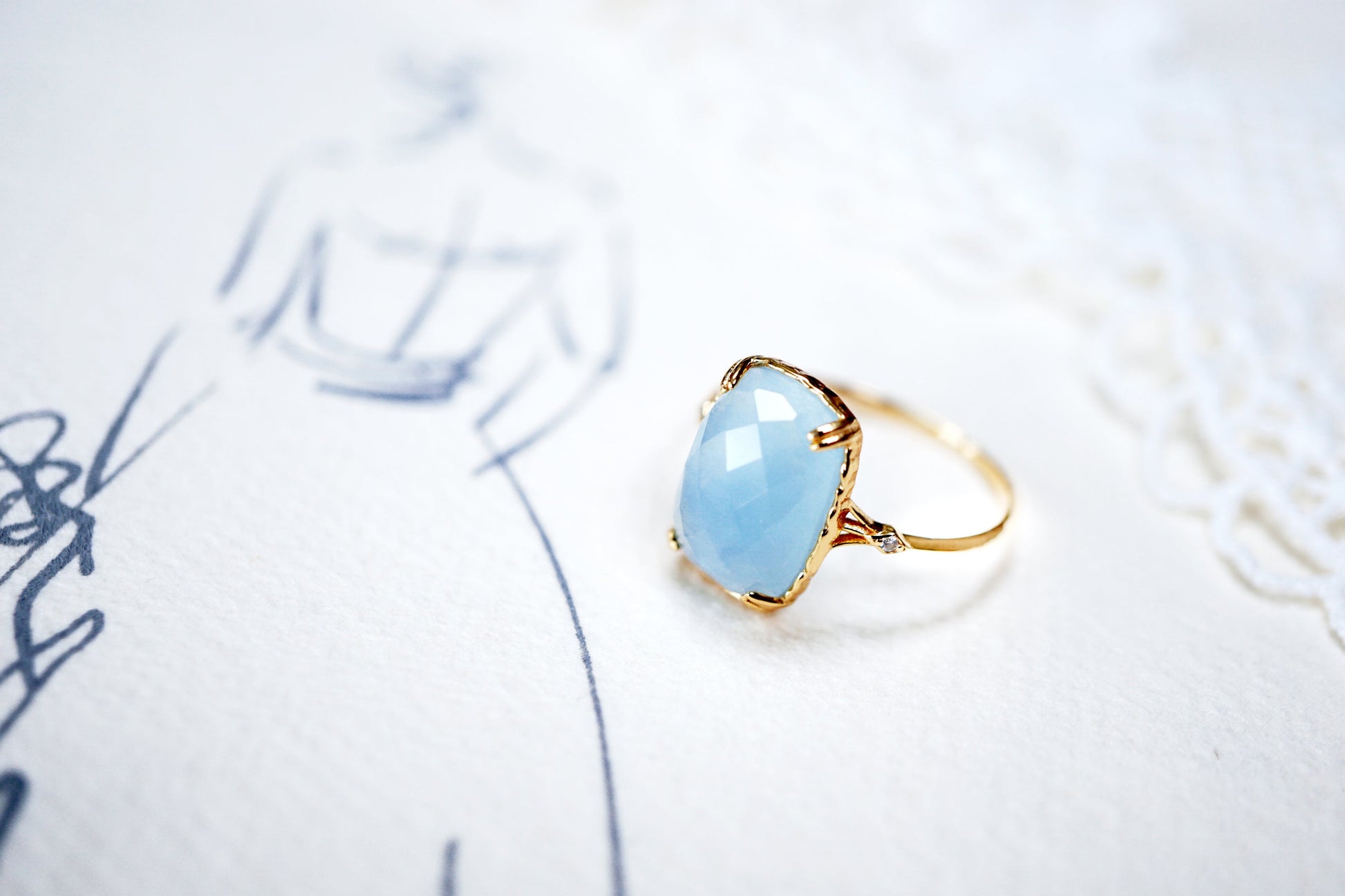 Gold ring with a blue gemstone on a white background