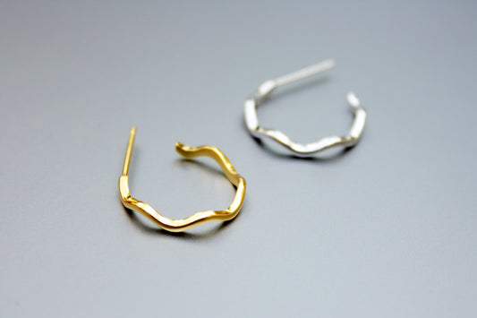 Gold and silver hoop earrings on a gray background