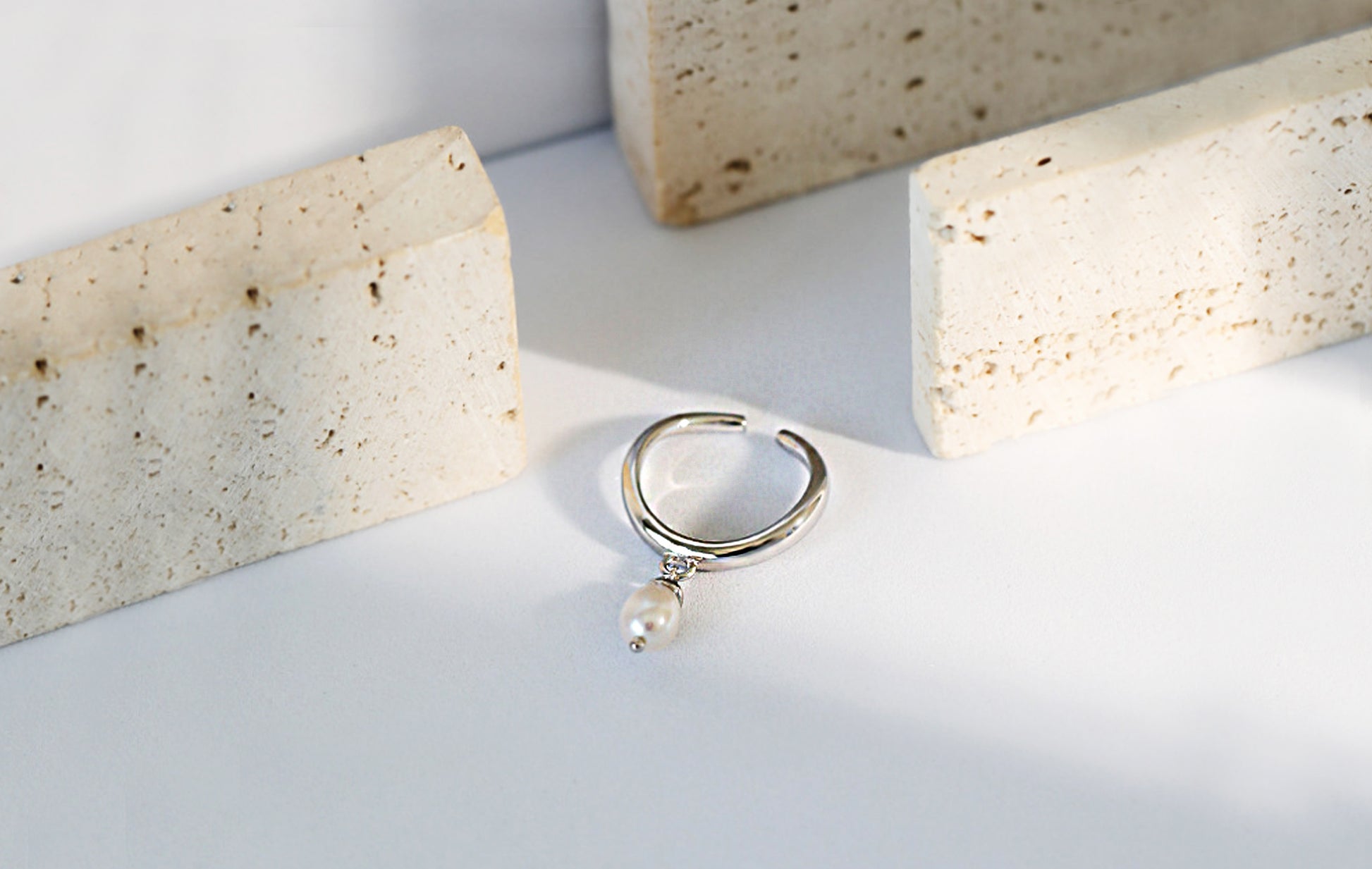 Silver ring with a pearl on a light background