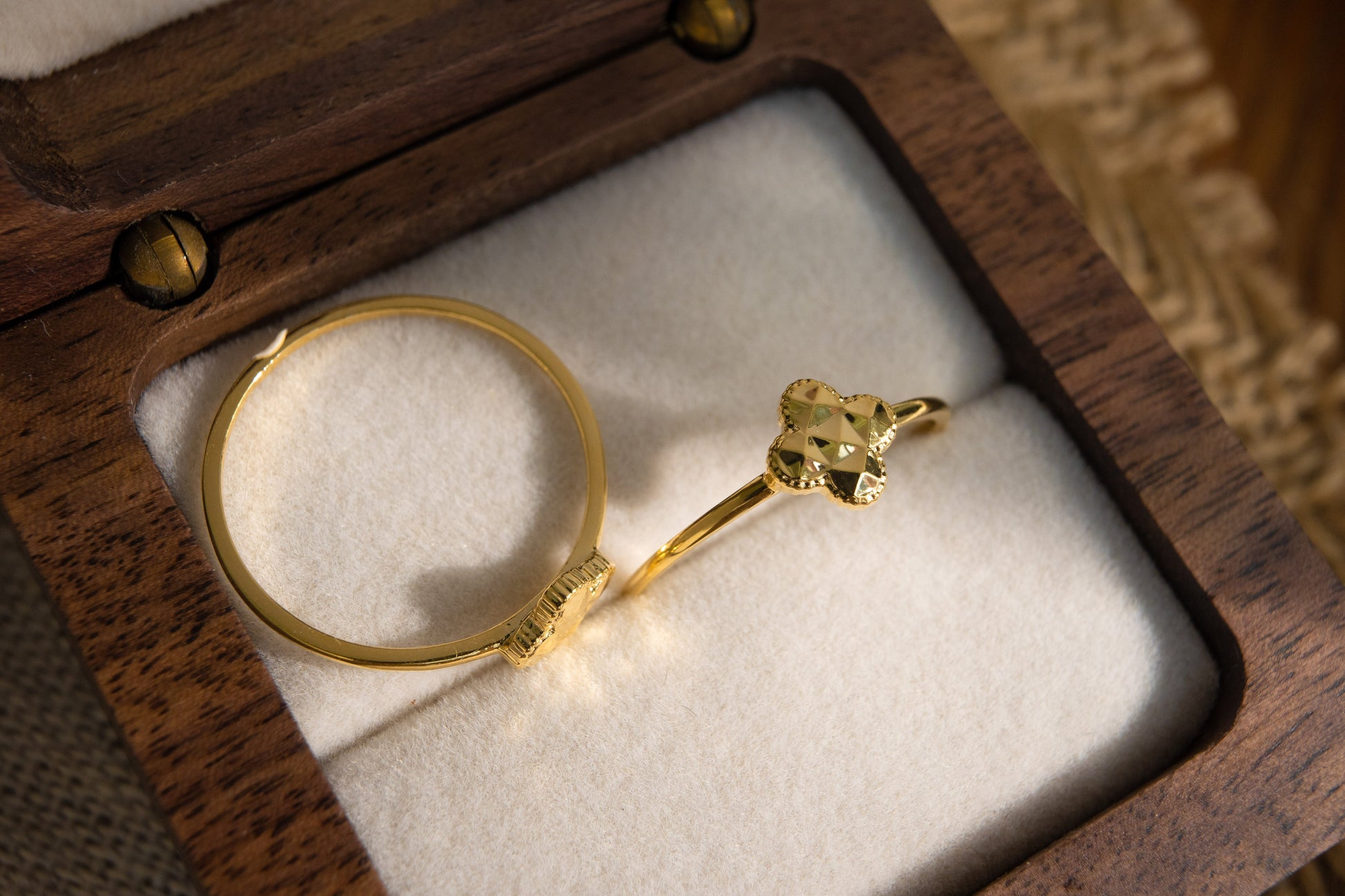 Gold bracelet with a unique design in a wooden jewelry box.