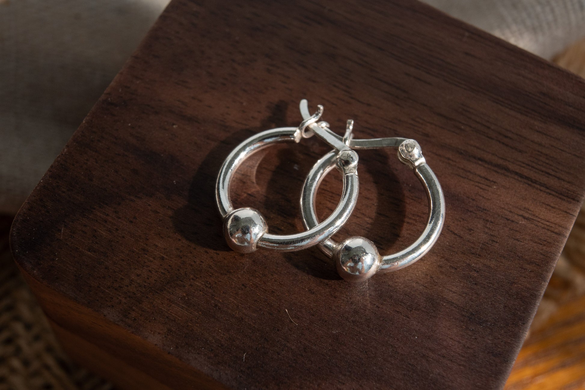 Silver hoop earrings on a wooden surface