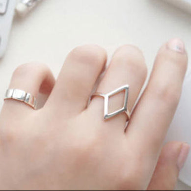 Silver geometric ring on a hand and on a white background