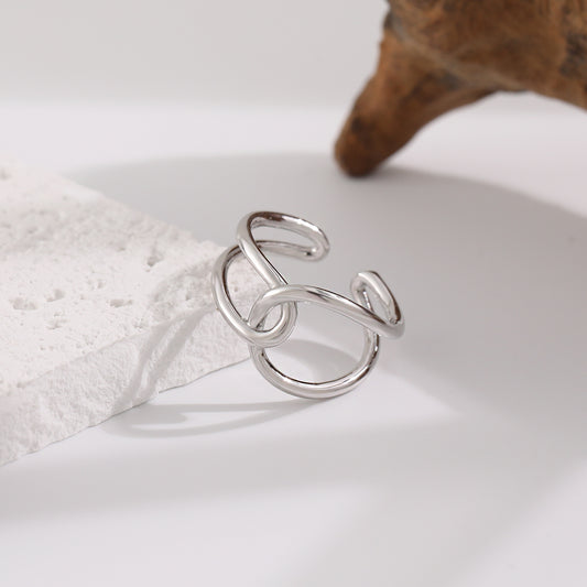 Silver ring on a white surface with a soft focus background