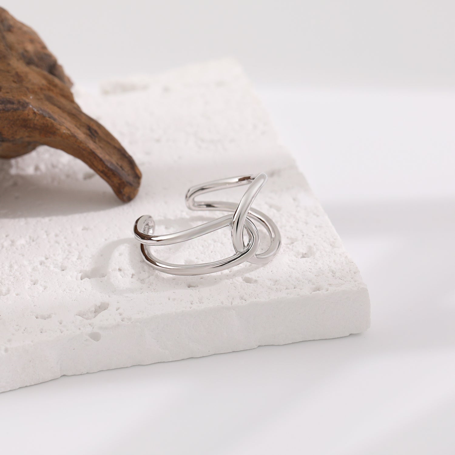 Silver ring with a diamond on a textured white surface