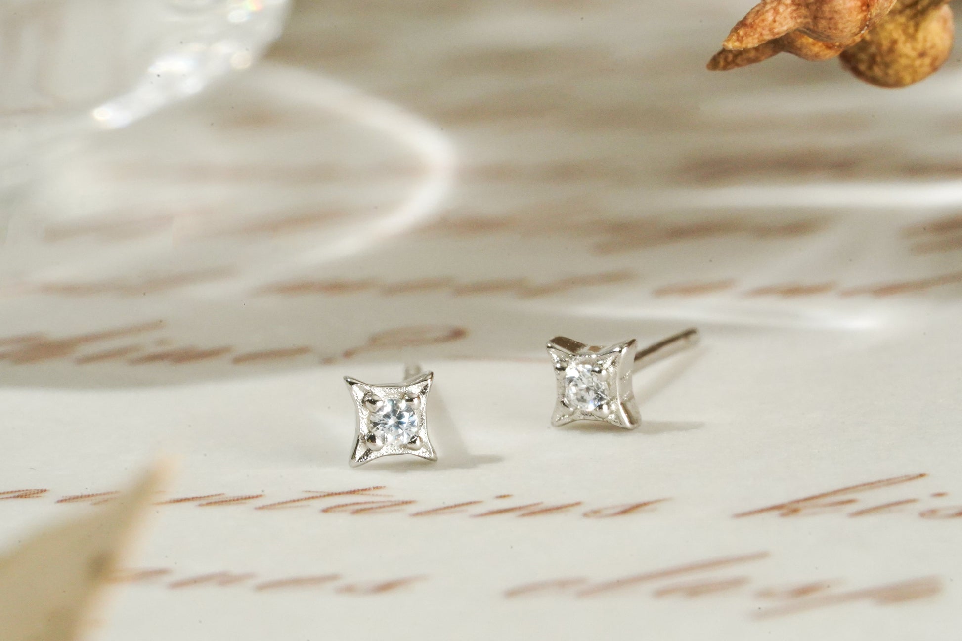 Pair of diamond stud earrings on a textured surface