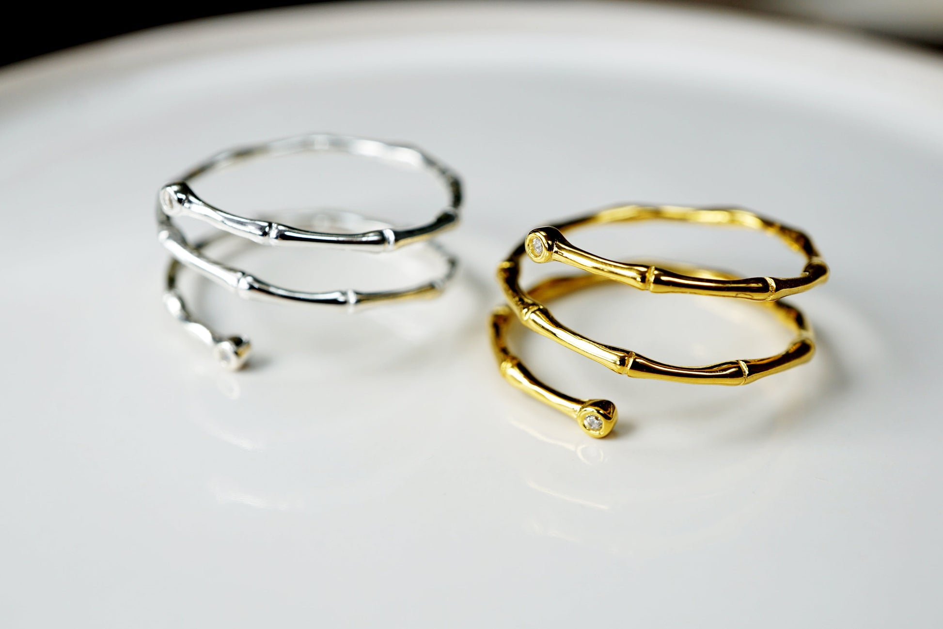Two gold and silver hoop earrings on a white plate
