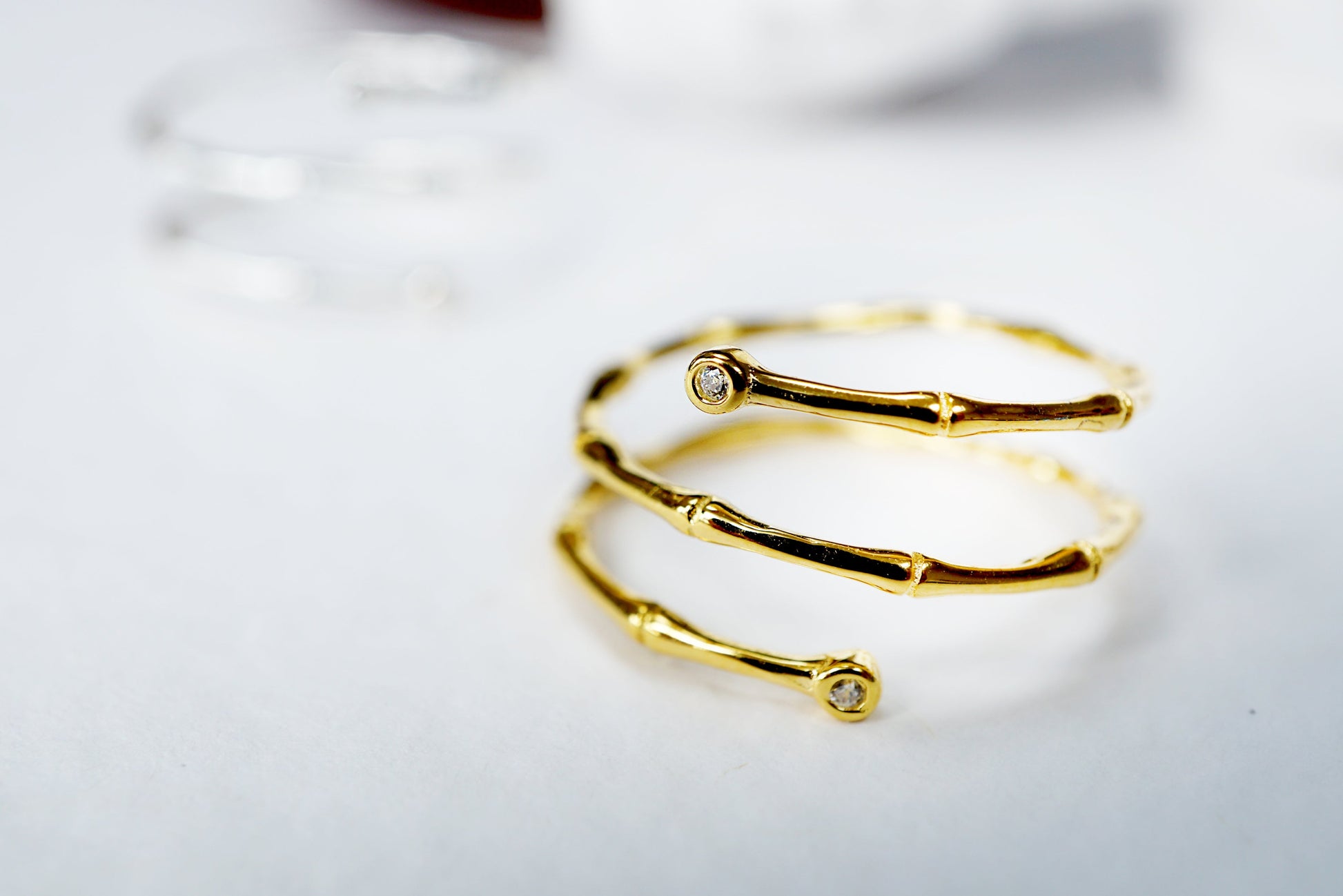 Gold bracelet with small stones on a light background