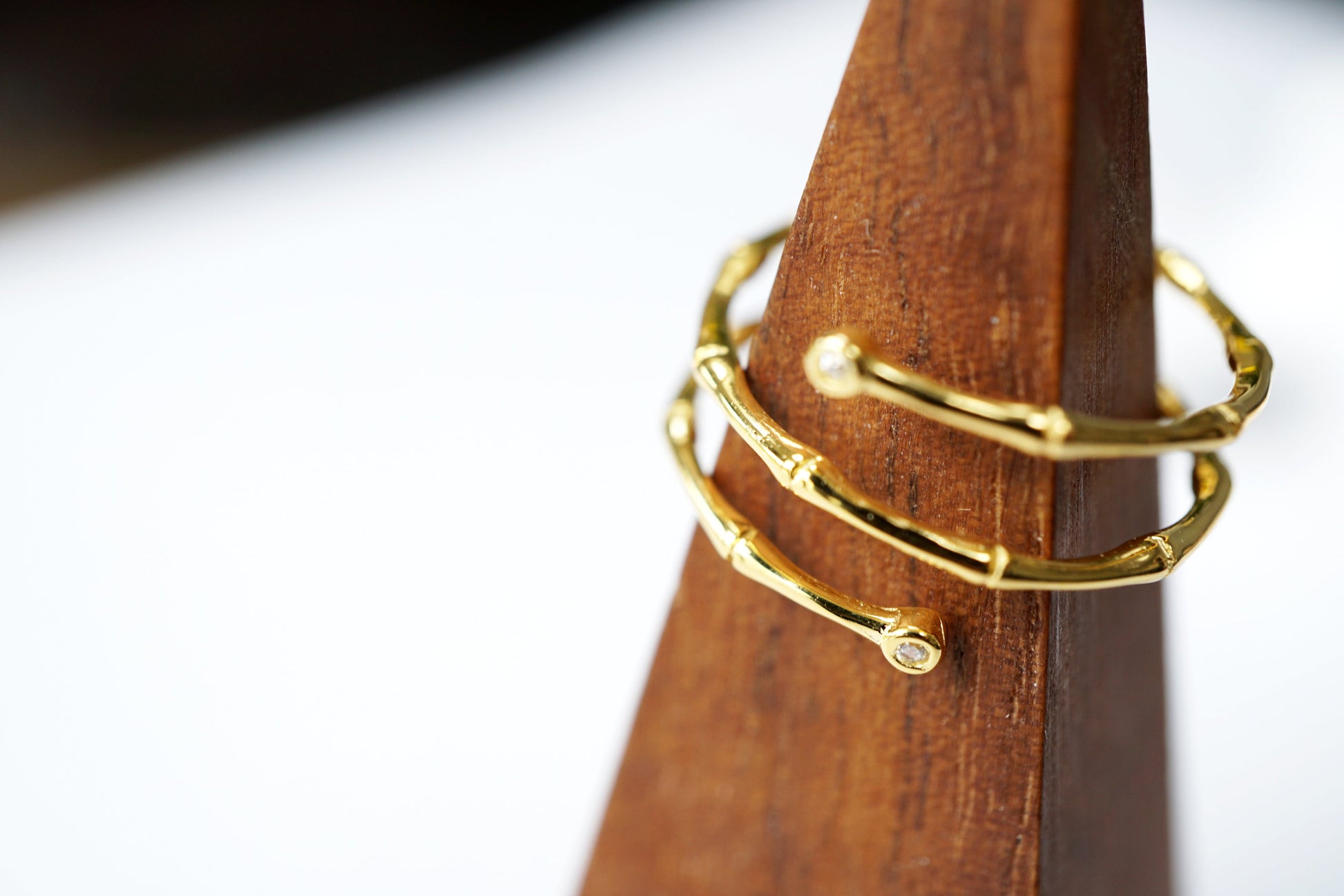 Gold ring on a wooden stand with a blurred background