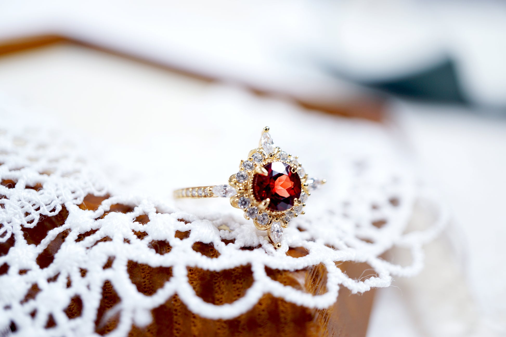 Gold ring with a red gemstone on a textured surface