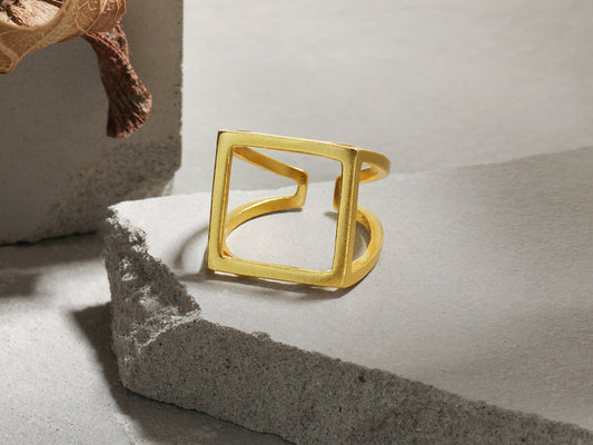 Gold ring on a textured surface with a neutral background